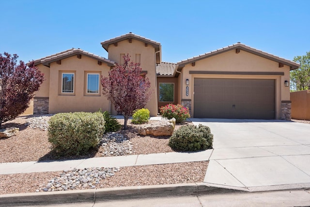 2659 Vista Manzano Loop NE, Rio Rancho, NM 87144 - view of front of property with a garage, concrete driveway, a tile roof, and stone siding