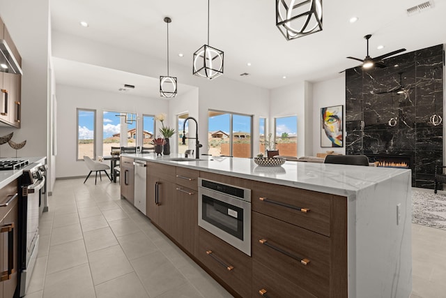 1413 6th St SE, Rio Rancho, NM 87124 - kitchen featuring appliances with stainless steel finishes, a fireplace, recessed lighting, ceiling fan, and a sink
