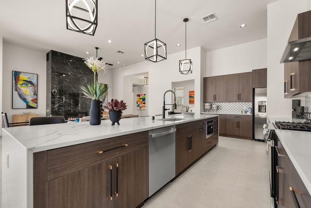 1413 6th St SE, Rio Rancho, NM 87124 - kitchen with appliances with stainless steel finishes, a sink, wall chimney exhaust hood, tasteful backsplash, and light tile patterned floors
