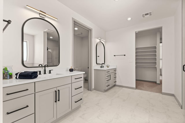 1413 6th St SE, Rio Rancho, NM 87124 - full bathroom featuring marble look tiles, two vanities, baseboards, toilet, and recessed lighting