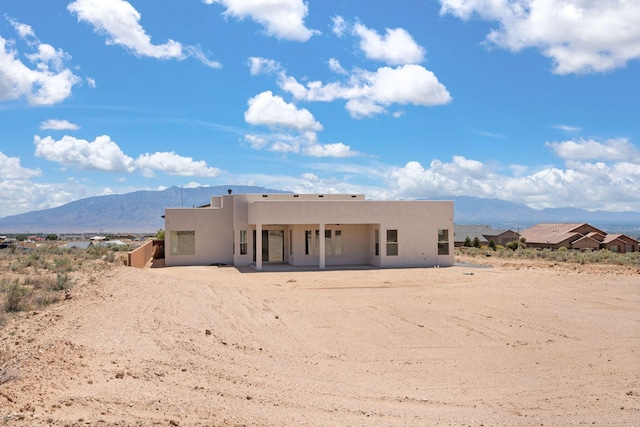 1413 6th St SE, Rio Rancho, NM 87124 - rear view of house with stucco siding, a mountain view, and a patio area