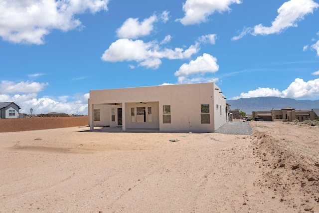 1413 6th St SE, Rio Rancho, NM 87124 - back of property featuring a ceiling fan, a mountain view, a patio, and stucco siding