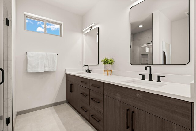 1413 6th St SE, Rio Rancho, NM 87124 - bathroom featuring double vanity, a stall shower, baseboards, and tile patterned flooring
