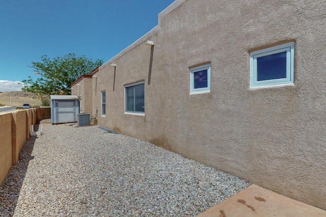 6500 Moon Shadows Dr NW, Albuquerque, NM 87120 - view of property exterior with stucco siding, central air condition unit, and a fenced backyard