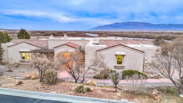 4110 Waterwillow Pl NW, Albuquerque, NM 87120 - mediterranean / spanish-style home featuring a tiled roof, stucco siding, a mountain view, and a chimney