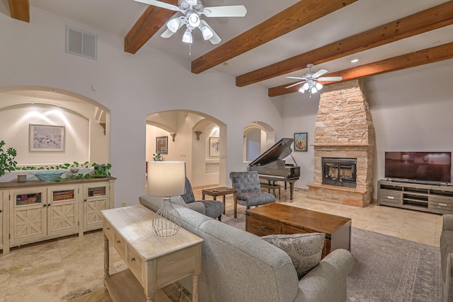 4110 Waterwillow Pl NW, Albuquerque, NM 87120 - living room with ceiling fan, beamed ceiling, a fireplace, arched walkways, and light tile patterned flooring
