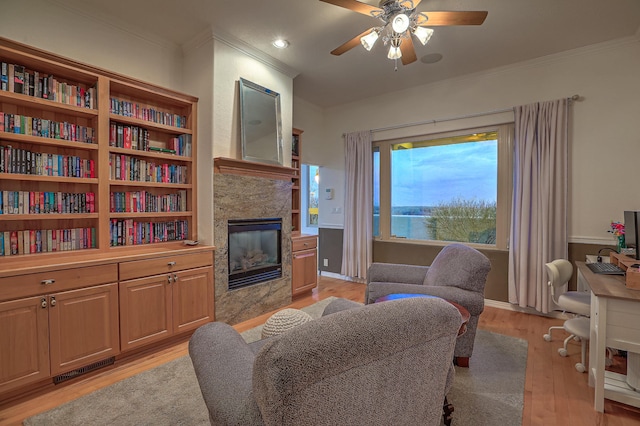 4110 Waterwillow Pl NW, Albuquerque, NM 87120 - living room featuring crown molding, ceiling fan, light wood-style flooring, a tile fireplace, and a desk