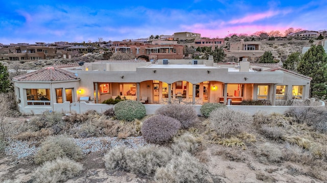 4110 Waterwillow Pl NW, Albuquerque, NM 87120 - back of property at dusk with stucco siding and a chimney