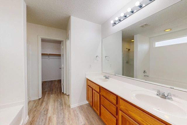 3702 Buckskin Loop NE, Rio Rancho, NM 87144 - full bathroom with a shower, a garden tub, wood finished floors, double vanity, and a walk in closet