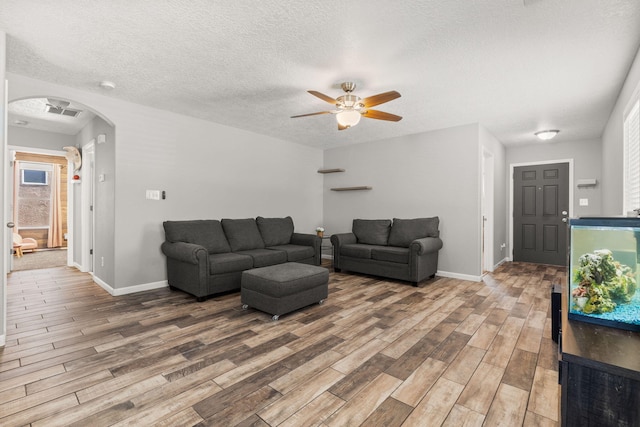 1227 Desert Paintbrush Loop, Rio Rancho, NM 87144 - living area featuring arched walkways, wood finished floors, baseboards, ceiling fan, and a textured ceiling