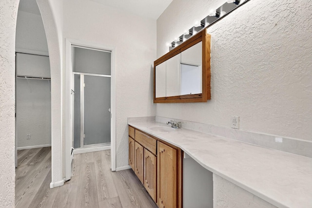 2517 Georgene Dr NE, Albuquerque, NM 87112 - bathroom featuring wood finished floors, a stall shower, vanity, a textured wall, and a spacious closet