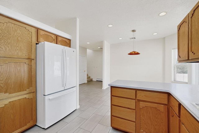 2517 Georgene Dr NE, Albuquerque, NM 87112 - kitchen featuring freestanding refrigerator, light countertops, a peninsula, a baseboard heating unit, and hanging light fixtures