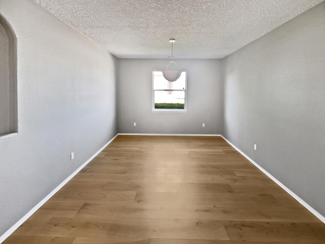 1713 Caramesa Dr SE, Rio Rancho, NM 87124 - unfurnished room with wood finished floors, a textured ceiling, and baseboards