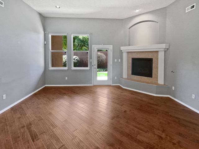 1713 Caramesa Dr SE, Rio Rancho, NM 87124 - unfurnished living room featuring wood finished floors, baseboards, a tiled fireplace, and recessed lighting