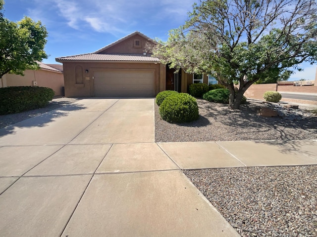 1713 Caramesa Dr SE, Rio Rancho, NM 87124 - view of front of property with a tiled roof, concrete driveway, stucco siding, and an attached garage