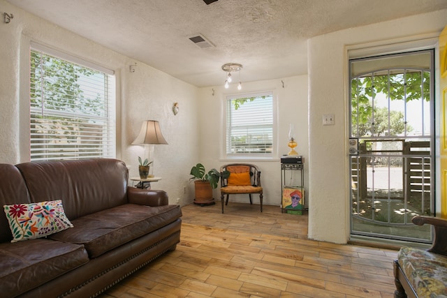 1508 Barelas Rd SW, Albuquerque, NM 87102 - living area featuring a textured wall, healthy amount of natural light, a textured ceiling, and wood finished floors