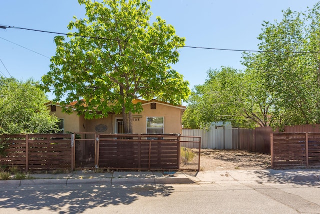 1508 Barelas Rd SW, Albuquerque, NM 87102 - view of front facade with stucco siding, a fenced front yard, and a gate