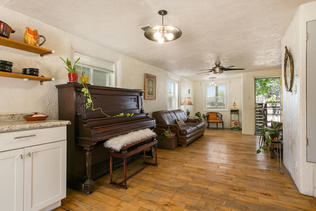 1508 Barelas Rd SW, Albuquerque, NM 87102 - living area with light wood-type flooring, ceiling fan, a textured ceiling, and a textured wall