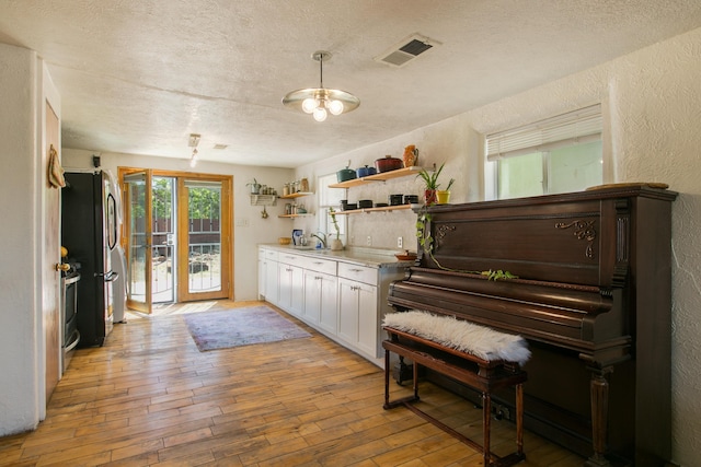 1508 Barelas Rd SW, Albuquerque, NM 87102 - sitting room featuring a textured wall, light wood-type flooring, and a textured ceiling