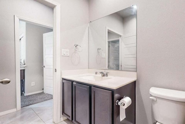 1472 Tierra Verde Loop, Los Lunas, NM 87031 - half bathroom featuring toilet, vanity, tile patterned flooring, and baseboards