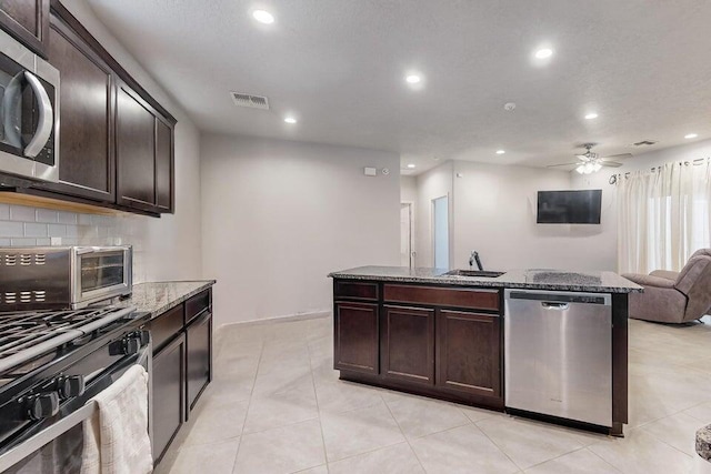 1472 Tierra Verde Loop, Los Lunas, NM 87031 - kitchen with stainless steel appliances, recessed lighting, stone counters, a sink, and open floor plan