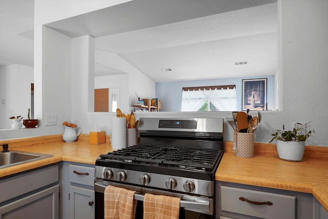4235 Pumice Dr NE, Rio Rancho, NM 87124 - kitchen with stainless steel range with gas stovetop, gray cabinets, a sink, wooden counters, and lofted ceiling