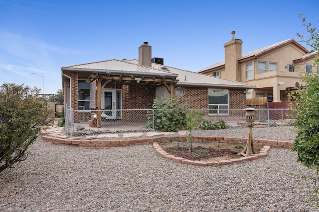 9200 Saguaro St NW, Albuquerque, NM 87114 - back of property featuring brick siding, a patio area, a chimney, and metal roof