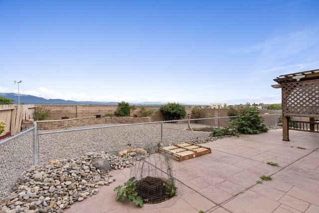 9200 Saguaro St NW, Albuquerque, NM 87114 - fenced backyard with a patio and a mountain view