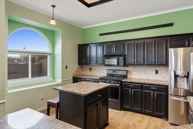 9200 Saguaro St NW, Albuquerque, NM 87114 - kitchen with stainless steel appliances, ornamental molding, backsplash, light stone counters, and hanging light fixtures