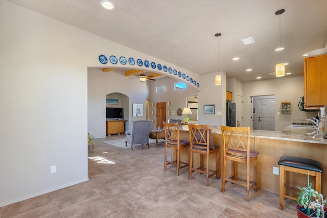 4612 Cactus Ave NW, Albuquerque, NM 87114 - kitchen featuring freestanding refrigerator, arched walkways, a peninsula, a ceiling fan, and a sink