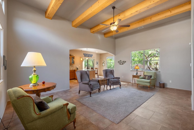 4612 Cactus Ave NW, Albuquerque, NM 87114 - living area with arched walkways, beam ceiling, a ceiling fan, a high ceiling, and baseboards