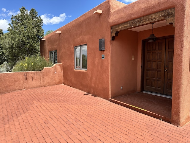 1704 Quail Run Ct NE, Albuquerque, NM 87122 - view of exterior entry with a patio area and stucco siding