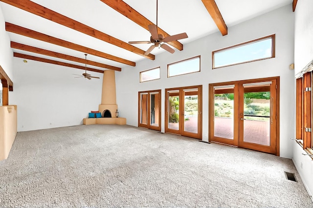 1704 Quail Run Ct NE, Albuquerque, NM 87122 - unfurnished living room featuring beamed ceiling, carpet flooring, a wood stove, french doors, and ceiling fan