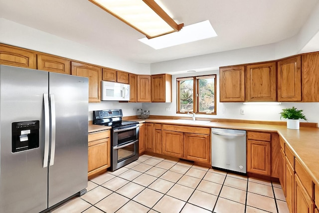 1704 Quail Run Ct NE, Albuquerque, NM 87122 - kitchen with stainless steel appliances, a sink, a skylight, and light countertops