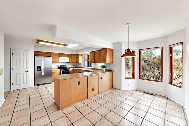 1704 Quail Run Ct NE, Albuquerque, NM 87122 - kitchen with appliances with stainless steel finishes, a peninsula, healthy amount of natural light, and light countertops