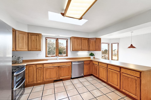 1704 Quail Run Ct NE, Albuquerque, NM 87122 - kitchen with stainless steel appliances, a sink, a peninsula, light countertops, and brown cabinetry