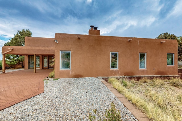 1704 Quail Run Ct NE, Albuquerque, NM 87122 - back of property with a chimney, stucco siding, and a patio area