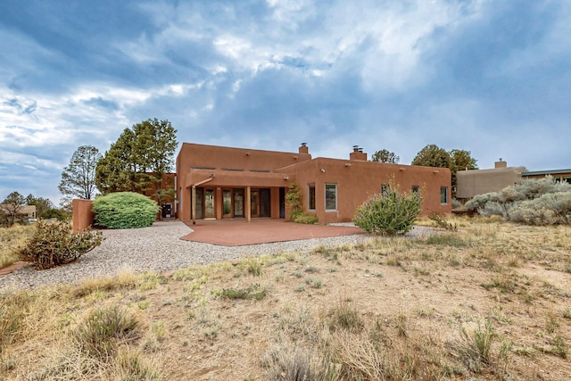 1704 Quail Run Ct NE, Albuquerque, NM 87122 - back of property featuring a chimney and a patio area
