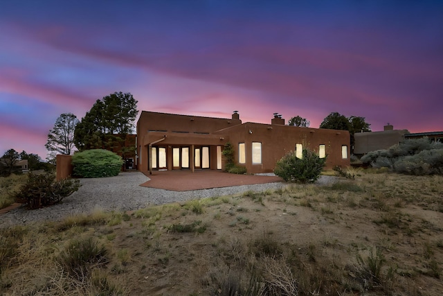 1704 Quail Run Ct NE, Albuquerque, NM 87122 - back of property featuring a patio area and a chimney