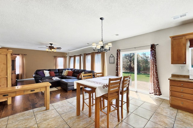 1412 Wind Ridge Dr NW, Albuquerque, NM 87120 - dining space featuring a chandelier, light tile patterned floors, ceiling fan, and a textured ceiling