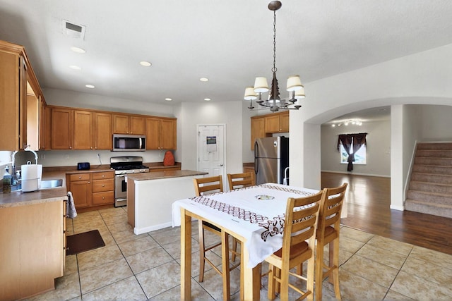 1412 Wind Ridge Dr NW, Albuquerque, NM 87120 - dining space featuring light tile patterned flooring, arched walkways, recessed lighting, a chandelier, and stairway