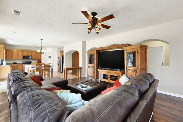 1412 Wind Ridge Dr NW, Albuquerque, NM 87120 - living area featuring arched walkways, a ceiling fan, wood finished floors, a chandelier, and a textured ceiling