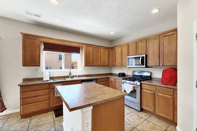1412 Wind Ridge Dr NW, Albuquerque, NM 87120 - kitchen featuring appliances with stainless steel finishes, a kitchen island, recessed lighting, light tile patterned floors, and brown cabinets