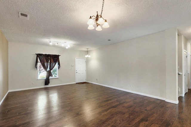 1412 Wind Ridge Dr NW, Albuquerque, NM 87120 - unfurnished living room featuring a chandelier, a textured ceiling, and dark wood finished floors