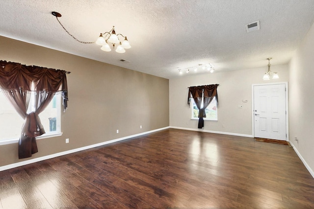 1412 Wind Ridge Dr NW, Albuquerque, NM 87120 - unfurnished room featuring a chandelier, a textured ceiling, and wood finished floors