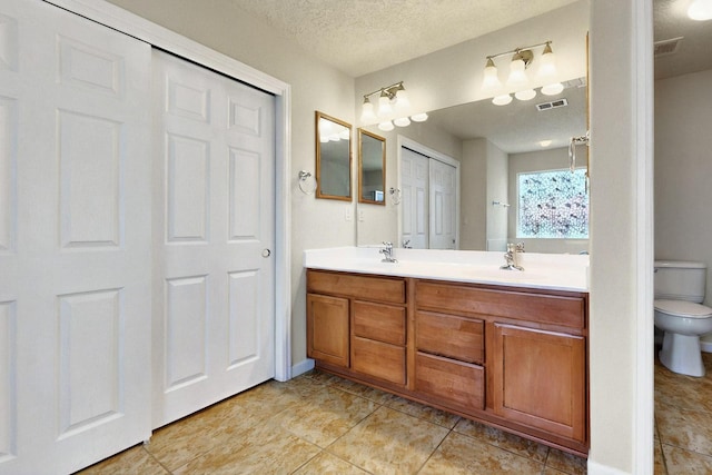 1412 Wind Ridge Dr NW, Albuquerque, NM 87120 - full bathroom with double vanity, a textured ceiling, and tile patterned floors