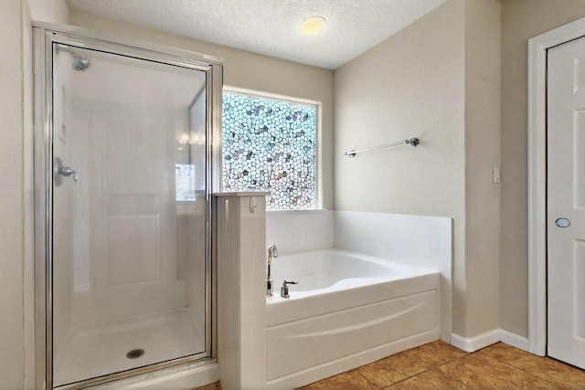 1412 Wind Ridge Dr NW, Albuquerque, NM 87120 - bathroom featuring a stall shower, a bath, tile patterned flooring, and a textured ceiling