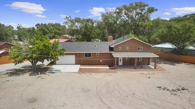 2212 Henry Rd SW, Albuquerque, NM 87105 - back of property with concrete driveway, a garage, covered porch, and stucco siding