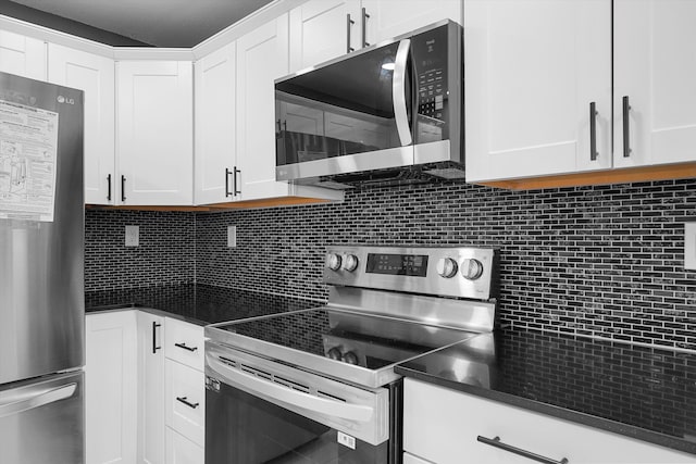2212 Henry Rd SW, Albuquerque, NM 87105 - kitchen with appliances with stainless steel finishes, decorative backsplash, white cabinets, and dark countertops