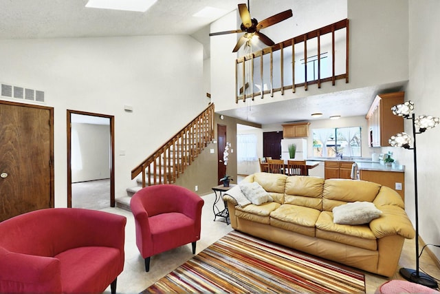 3039 Prenda De Oro Dr NW, Albuquerque, NM 87120 - living room featuring high vaulted ceiling, stairs, light carpet, healthy amount of natural light, and a ceiling fan